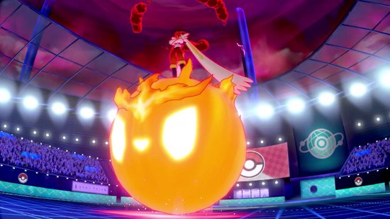 Een gigantische vuurbal-Pokémon met gloeiende ogen in een stadion.
