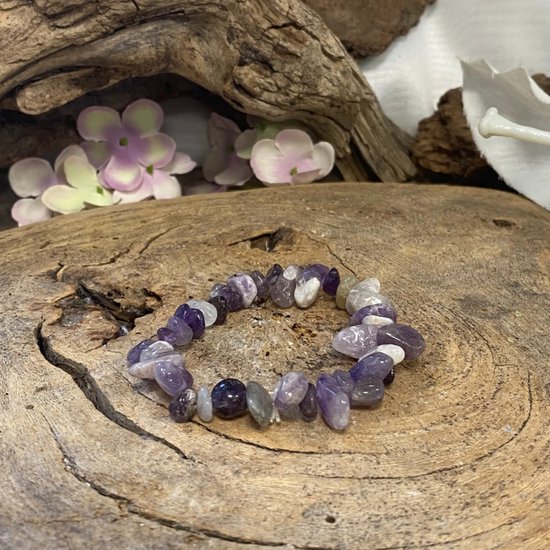 Amethist splitsteen armband op een houten ondergrond, met paarse en witte steentjes.