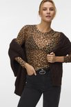 Model draagt een bruine mesh top met luipaardprint, gecombineerd met een zwarte riem en jeans.