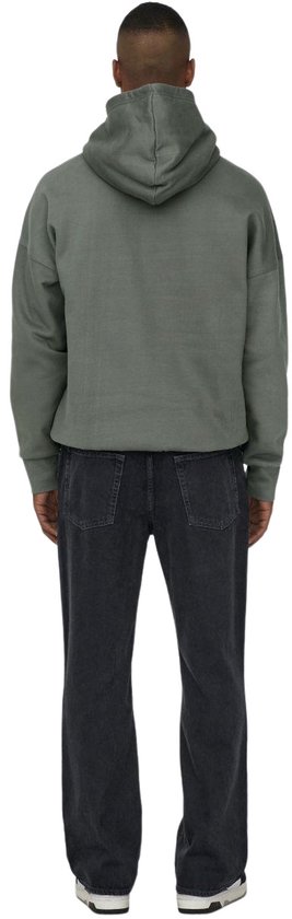Een man draagt een grijze hoodie van katoen en een zwarte jeans, rug naar de camera.