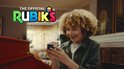 Jongen met kroeshaar houdt een Rubik's Cube vast, met logo 'The Official Rubik's'.