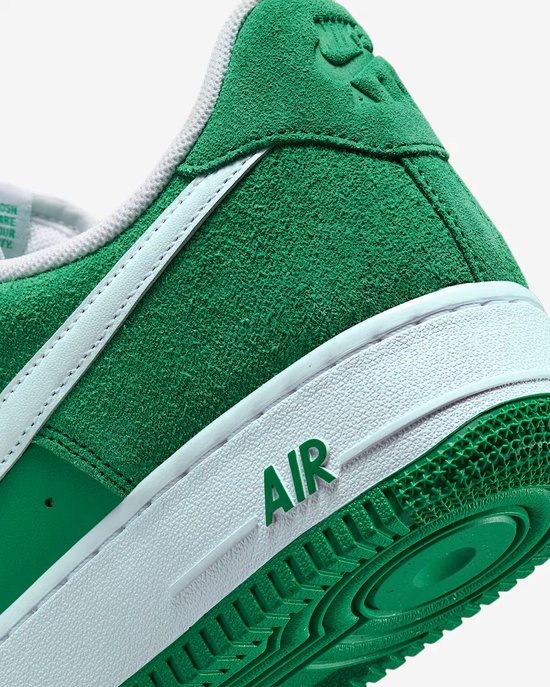 Detail van de hiel en zijkant van een groene Nike Air Force 1 '07 LV8 sneaker met witte Swoosh en 'AIR' op de zool.