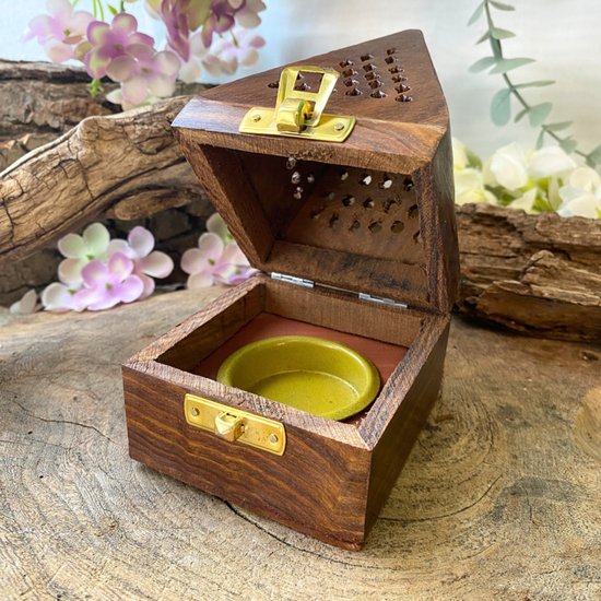 Boîte à encens en bois, ouverte, avec un petit bol vert à l'intérieur. Fermoirs dorés.