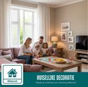 Gezin speelt een spel in een sfeervolle woonkamer met roze bank en raamfolie. Tekst: 'Huiselijke decoratie'.
