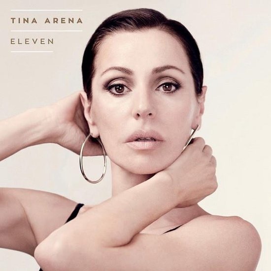 Tina Arena met grote oorringen, handen in haar nek. Titel "ELEVEN".