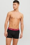Model draagt zwarte boxershorts met rode tailleband met JACK & JONES logo.