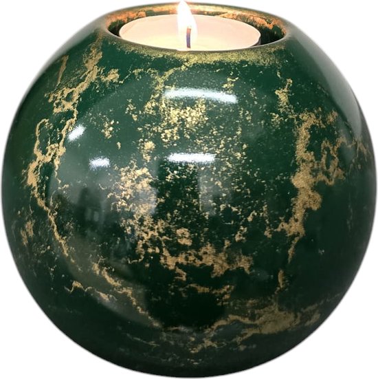 Groene, bolvormige kaarsenhouder met gouden details, met brandend kaarsje.