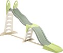 Een groene en beige glijbaan met een trap, staand op gras.