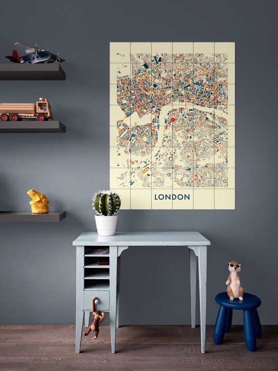 Une chambre d'enfant avec une carte de la ville de Londres en bleu, orange et rouge sur fond crème, accrochée au mur.
