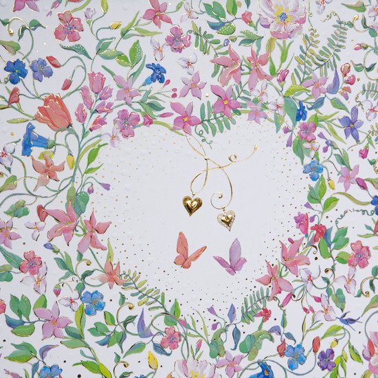 Detail van een wit fotoalbum met een hartvormige krans van kleurrijke bloemen en vlinders, met gouden hartjes en stippen.