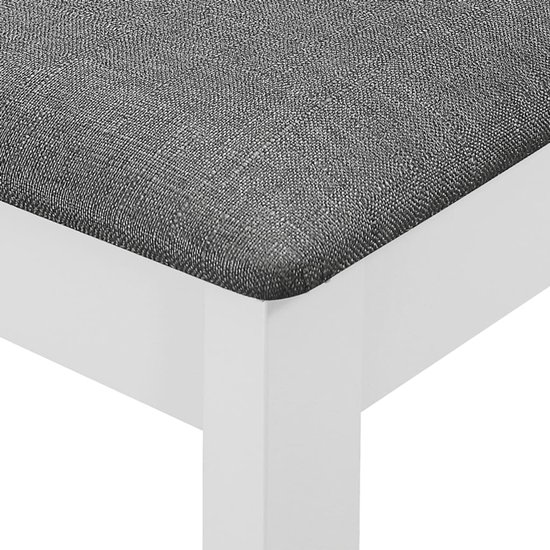 Gros plan d'un pied de chaise blanc avec une assise en tissu gris texturé.