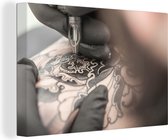 Un tatoueur au travail toile 120x80 cm - Tirage photo sur toile (Décoration murale salon / chambre)