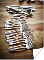 Verzameling zilveren vorken lepels en ander keukengerei wat evenredig over de eikenhouten tafel verspreid ligt 30x40 cm - klein - Foto print op Poster (wanddecoratie woonkamer / slaapkamer)