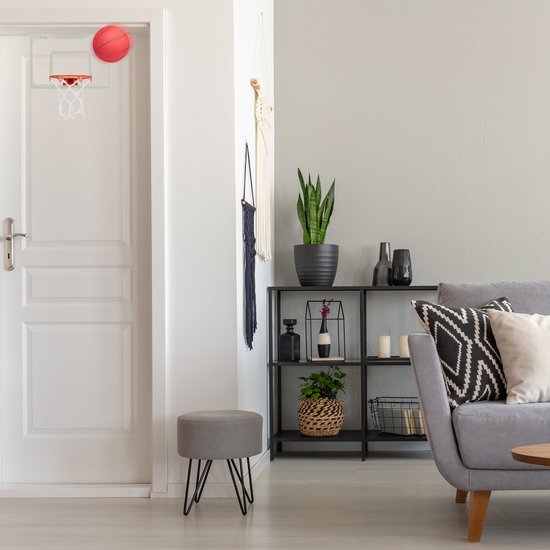 Indoor basketbalspel in een woonkamer, met rode mini basketbal op een doorhangend bord boven de deur.