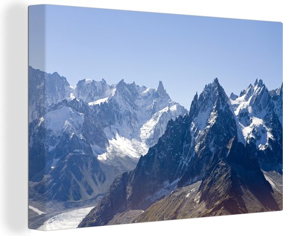 Canvas Schilderij Besneeuwde toppen in jonge bergen - 60x40 cm - Wanddecoratie
