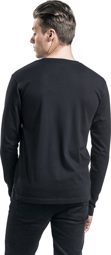 Achterkant van een man met blond haar, draagt zwart longsleeve shirt, zwarte jeans.