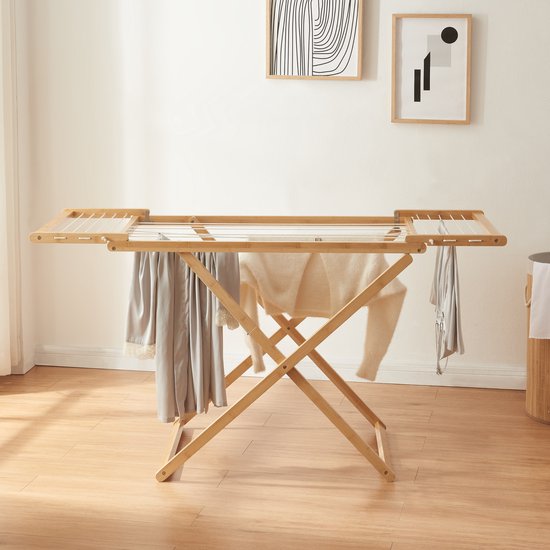 Houten droogrek met witte waslijnen, met kledingstukken.