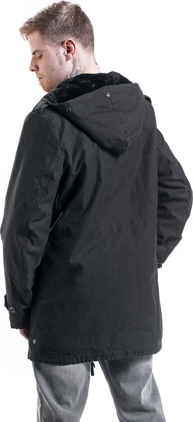 Achterkant van een man in zwarte parka met capuchon en bontkraag.