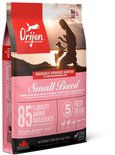 Orijen Small Breed hondenvoer met silhouette van vrouw en hond bij zonsondergang. Bevat 85% dierlijke ingrediënten, vers of rauw.