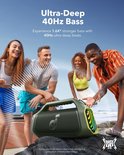 Groene speaker op een rots op het strand, met vier lachende vrienden op de achtergrond.