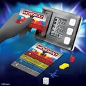 Monopoly Super Elektronisch Bankieren met bankautomaat, bankpassen en speelstukken zoals een auto en vliegtuig.