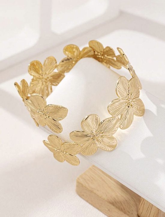 Gouden armband bezet met gestileerde bloemen.