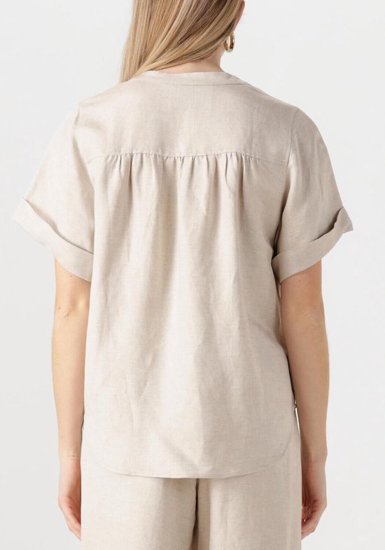 Achterkant van een beige linnen blouse met korte, opgerolde mouwen.