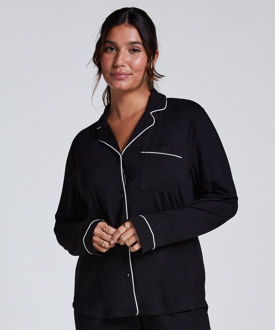 Model met lang gebreid nachthemd in zwart met witte biezen en knoopsluiting.