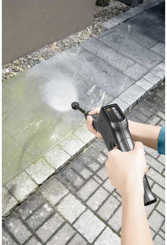 Hand met hogedrukreiniger spuitend op een betegeld tuinpad.