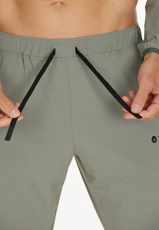 Grijze sportbroek met trekkoord aan de voorkant, gedragen door een man.