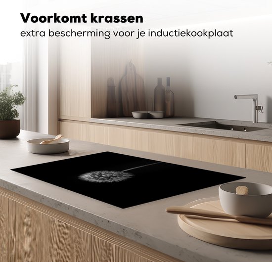 Zwarte inductiebeschermer met paardenbloemprint, die krasbescherming biedt voor de kookplaat.