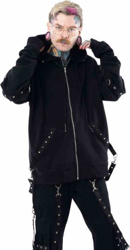 Man met getrokken wenkbrauwen en roze haar accenten trekt de capuchon van een zwarte hoodie met studs en banden aan.