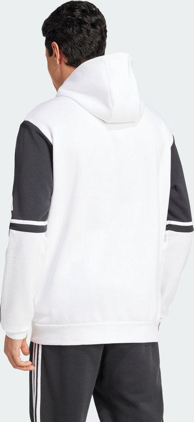 Man met de rug naar ons toe, draagt een witte capuchontrui met donkergrijze mouwen en zwarte Adidas-strepen.