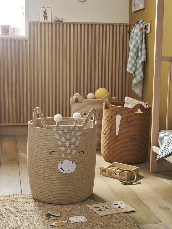 Trois paniers de rangement dans une chambre d'enfant: un panier beige avec visage de girafe, un panier beige avec visage de chat et un panier marron avec visage de tigre.
