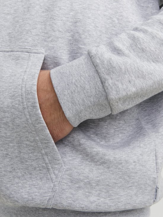Sluiting van de steekzak van een grijze hoodie. Jack & Jones logo op de rand.