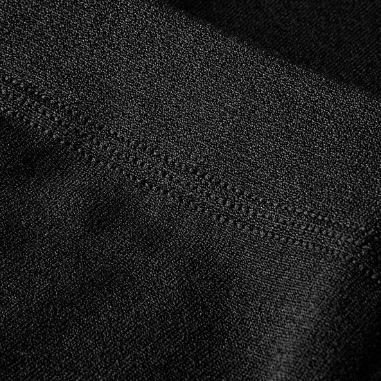 Detail van de textuur en naad van een zwarte thermische legging.