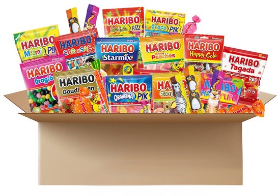 Open kartonnen doos gevuld met diverse Haribo en Fruit-tella snoepzakjes en snoep.