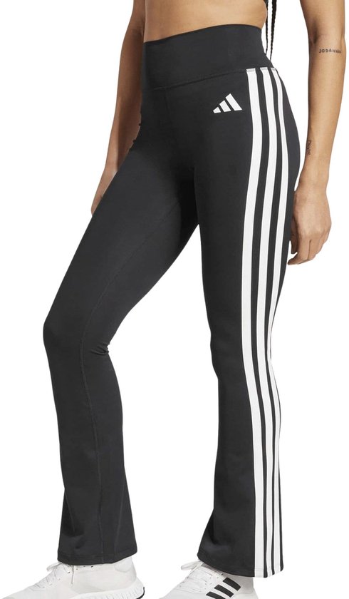 Model in zwarte flared legging met witte Adidas stripes.