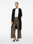 Vrouw met luipaardprint broek met wijde pijpen en zwarte lange vest.