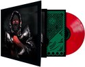Zijzicht op een platenhoes met een man in zwarte capuchon en rood geschminkt gezicht, naast een rode vinylplaat.