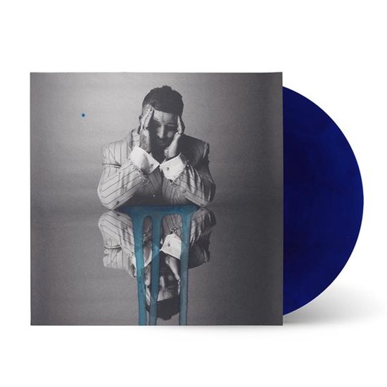 Hoes van de vinyl 'UGLY' met een man in een gestreept pak, zittend met zijn handen op zijn hoofd, met een blauwe vlek en een reflectie op de hoes. De vinyl zelf is diepblauw.