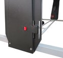 Zwart frameonderdeel met een rode knop voor het in- en uitklappen van de tafel.