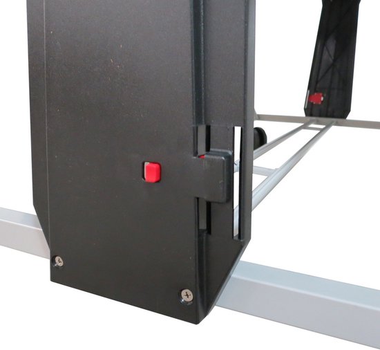 Zwart frameonderdeel met een rode knop voor het in- en uitklappen van de tafel.