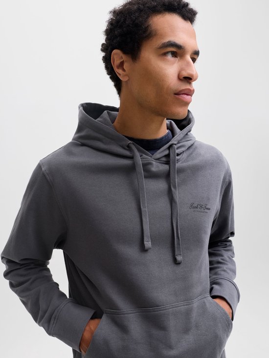 Man in donkergrijze hoodie, zijaanzicht, met capuchon en kangoeroezak.