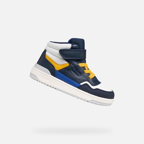 Dynamisch zijaanzicht van een marineblauwe hoge sneaker met witte, blauwe en gele vlakken.