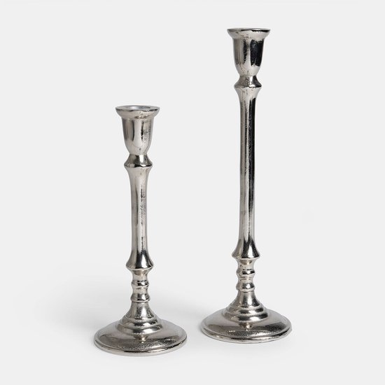 Set van twee klassieke, zilverkleurige kandelaren van verschillende hoogtes.
