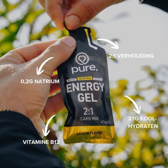 Handen openen een zwarte Pure energy gel citroen. Kenmerken: 2:1 verhouding, 27g koolhydraten, 0,2g natrium, vitamine B12.