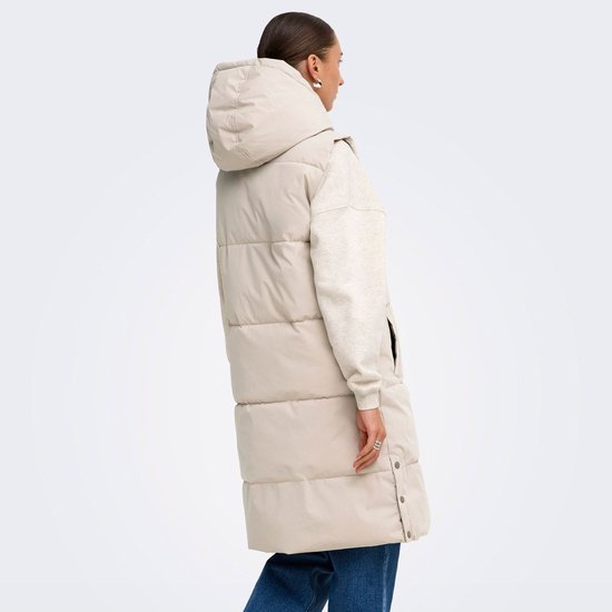 Model van achteren gezien in een lange, lichtgrijze gewatteerde bodywarmer met capuchon.