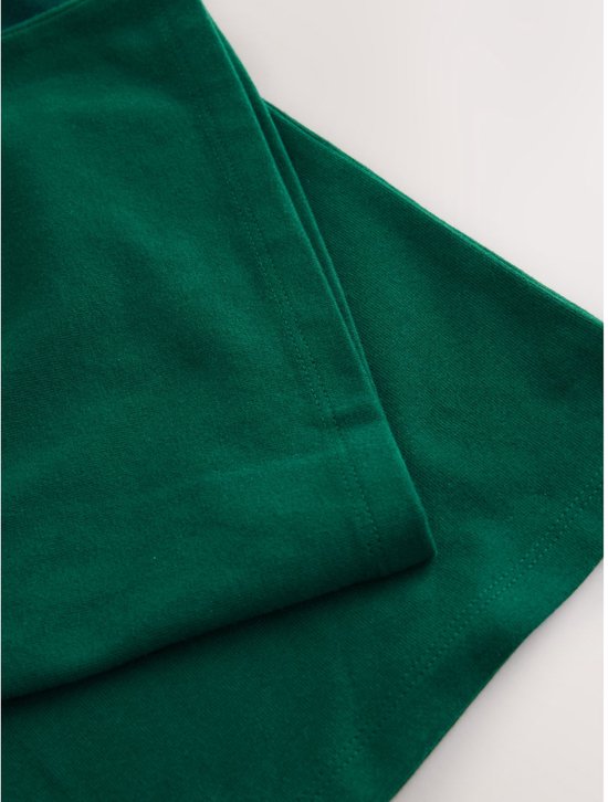 Detail van een groene wijde broek met gestikte zomen.