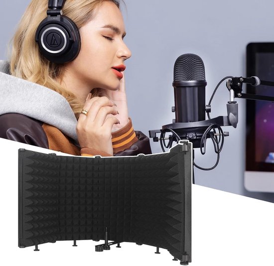 Vrouw met koptelefoon zingt voor microfoon, naast een opvouwbaar zwart isolatieschild.